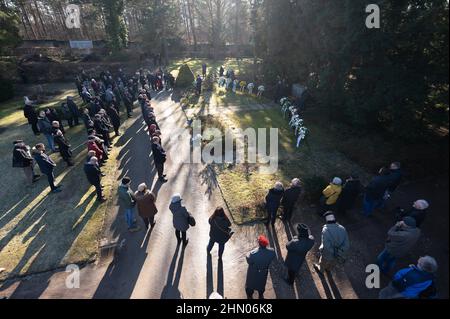 Dresden, Deutschland. 13th. Februar 2022. Die Teilnehmer einer Gedenkfeier stehen auf dem Nordfriedhof. Am 13. Und 14. Februar 1945 reduzierten alliierte Bomber das Zentrum der Stadt an der Elbe in Schutt und Asche. Bis zu 25.000 Menschen verloren ihr Leben. Quelle: Sebastian Kahnert/dpa-Zentralbild/dpa/Alamy Live News Stockfoto