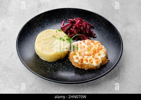 Kiewer Zitronen mit Kartoffelpüree und eingelegter Rote Bete auf einem Teller Stockfoto