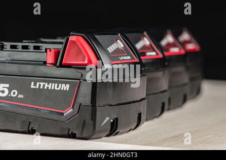 Akku für Akku-Bohrmaschine. Schrauberbatterie. Vier Akkus mit Ladeanzeige auf schwarzem Hintergrund Stockfoto