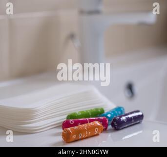 Damenbinden und medizinische weibliche Tampons auf dem Badezimmertisch. Hygieneprodukte für Frauen Stockfoto