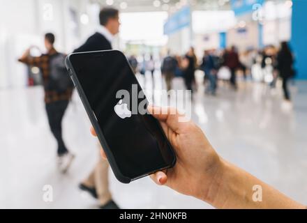 Frau Hand hält iphone XS mit Logo von Apfel, hergestellt von Apple Computer, Inc. Stockfoto