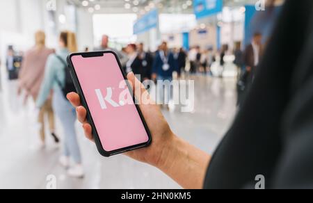 Frau Hand hält iphone XS mit Logo von Klarna Bank ab auf einem Smartphone angezeigt. Stockfoto