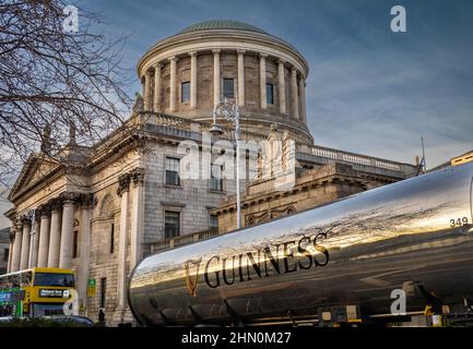 Ein Guinness-Biertanker vor dem historischen Four Courts-Gebäude am Inns Quay neben dem Fluss Liffey in Dublin, Irland. Die Vier Gerichte (Irisch: Na Stockfoto