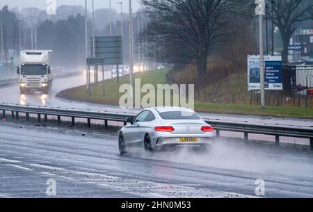 Dundee, Tayside, Schottland, Großbritannien. 13th. Februar 2022. UK Wetter: Nordostschottland erlebt leichte Winde und sintflutartige Regengüsse mit Temperaturen bis zu 7 Grad Sonntagfahrer auf der vielbefahrenen Dundee Kingsway West-Schnellstraße stehen vor gefährlichen und nassen Bedingungen. Kredit: Dundee Photographics/Alamy Live Nachrichten Stockfoto