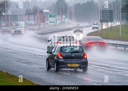 Dundee, Tayside, Schottland, Großbritannien. 13th. Februar 2022. UK Wetter: Nordostschottland erlebt leichte Winde und sintflutartige Regengüsse mit Temperaturen bis zu 7 Grad Sonntagfahrer auf der vielbefahrenen Dundee Kingsway West-Schnellstraße stehen vor gefährlichen und nassen Bedingungen. Kredit: Dundee Photographics/Alamy Live Nachrichten Stockfoto