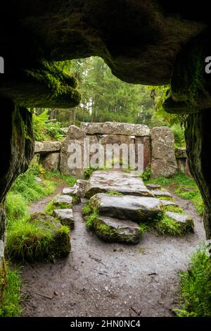 Blick aus einer künstlichen Höhle auf einen Altar und stehende Steine am Druids Temple, eine Torheit in Ilton in der Nähe von Masham, North Yorkshire Stockfoto