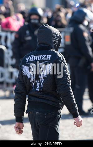 Dresden, Deutschland. 13th. Februar 2022. Ein Teilnehmer einer Neonazis-Kundgebung trägt eine Jacke der Modemarke Yakuza. Die Prozession, die als schweigender marsch erklärt wurde, wurde von mehreren Gegendemonstrationen begleitet. Quelle: Sebastian Kahnert/dpa-Zentralbild/dpa/Alamy Live News Stockfoto