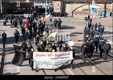 Dresden, Deutschland. 13th. Februar 2022. Zahlreiche Neonazis laufen bei einer Kundgebung vor dem Bahnhof Mitte entlang. Die Prozession, die als schweigender marsch erklärt wurde, wurde von mehreren Gegendemonstrationen begleitet. Quelle: Sebastian Kahnert/dpa-Zentralbild/dpa/Alamy Live News Stockfoto