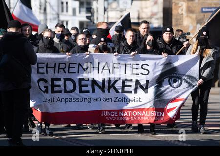 Dresden, Deutschland. 13th. Februar 2022. Zahlreiche Neonazis halten bei einer Kundgebung vor dem Bahnhof Mitte ein Transparent mit der Aufschrift "Ehrenhafte Erinnerung". Die Prozession, die als schweigender marsch erklärt wurde, wurde von mehreren Gegendemonstrationen begleitet. Quelle: Sebastian Kahnert/dpa-Zentralbild/dpa/Alamy Live News Stockfoto