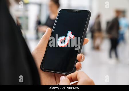 Frau, die ein iPhone XS hält, um die Tik Tok-Anwendung zu öffnen. TIK Tok Symbol. tik Tok Anwendung. TikTok Social-Media-Netzwerk. Stockfoto