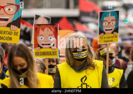 Madrid, Spanien. 13th. Februar 2022. Menschen protestierten mit Plakaten während einer Demonstration gegen das sogenannte Gag-Gesetz (Ley Mordaza). Die Bürgerplattform „No Somos Delito“ hat zusammen mit Gruppen, Organisationen und sozialen Bewegungen, die sich für die Verteidigung der Menschenrechte einsetzen, zu einer Demonstration aufgerufen, um zu fordern, dass die von der Regierung vorgeschlagene Reform des Gag-Gesetzes auf einige Mindestvorgaben reagiert, die die freie Ausübung der Grundrechte garantieren. Quelle: Marcos del Mazo/Alamy Live News Stockfoto