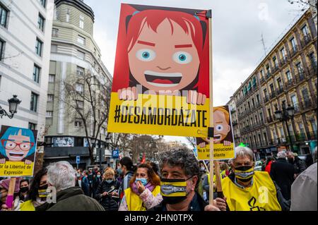 Madrid, Spanien. 13th. Februar 2022. Menschen protestierten mit Plakaten während einer Demonstration gegen das sogenannte Gag-Gesetz (Ley Mordaza). Die Bürgerplattform „No Somos Delito“ hat zusammen mit Gruppen, Organisationen und sozialen Bewegungen, die sich für die Verteidigung der Menschenrechte einsetzen, zu einer Demonstration aufgerufen, um zu fordern, dass die von der Regierung vorgeschlagene Reform des Gag-Gesetzes auf einige Mindestvorgaben reagiert, die die freie Ausübung der Grundrechte garantieren. Quelle: Marcos del Mazo/Alamy Live News Stockfoto