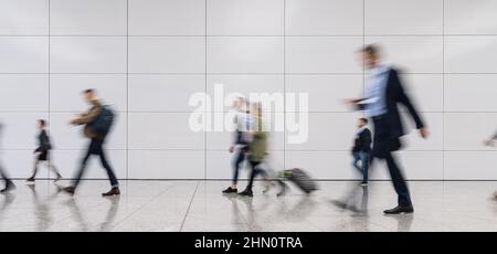 Die Gruppe der Geschäftsleute steht auf einer Messe in anonymer, verschwommener Menschenmenge Stockfoto