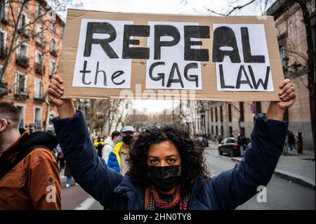 Madrid, Spanien. 13th. Februar 2022. Eine Frau, die während einer Demonstration gegen das als Gag Law (Ley Mordaza) bekannte Gesetz zur Sicherheit der Menschen mit einem Plakat protestierte. Die Bürgerplattform „No Somos Delito“ hat zusammen mit Gruppen, Organisationen und sozialen Bewegungen, die sich für die Verteidigung der Menschenrechte einsetzen, zu einer Demonstration aufgerufen, um zu fordern, dass die von der Regierung vorgeschlagene Reform des Gag-Gesetzes auf einige Mindestvorgaben reagiert, die die freie Ausübung der Grundrechte garantieren. Quelle: Marcos del Mazo/Alamy Live News Stockfoto