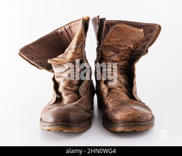 Alte Schuhe auf weißem Hintergrund. Brauner Lederschuh. Abgenutzte Schuhe. Stiefel. Stockfoto