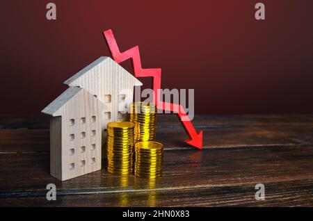 Roter Pfeil nach unten und Häuser. Fallender Immobilienmarkt. Niedrige Wohnungspreise. Reduzierte Hypothekenzinsen. Krise. Wartungskosten. Rezession. Gehäuseblasen Stockfoto