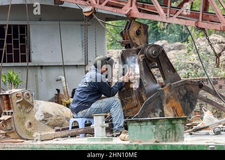 Ein Vietnamese repariert einen Kran, indem er auf einem Boot auf dem Mekong-Delta, Vinh Long Province, Südvietnam, Südostasien schweißen lässt Stockfoto