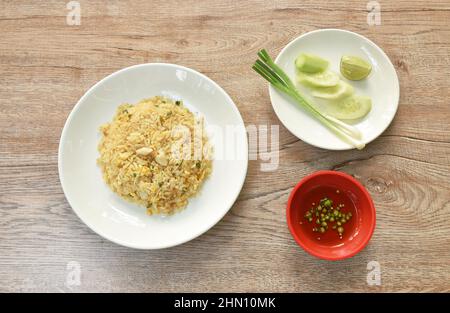 Gebratenes Reiskrabbenfleisch und Ei mit Gurkenscheiben und ein paar Zitronen auf dem Teller Stockfoto