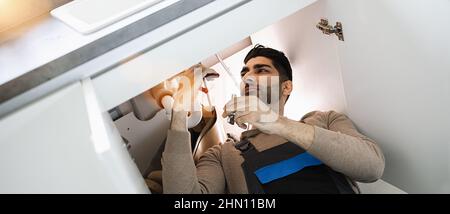 Klempner repariert Spülbecken in der Küche Stockfoto