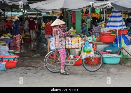 Eine reife Vietnamesin verkauft ihre Produkte auf dem geschäftigen Lebensmittelmarkt am Morgen in Cai Rang, in der Nähe von Can Tho, Mekong Delta, Südvietnam Stockfoto