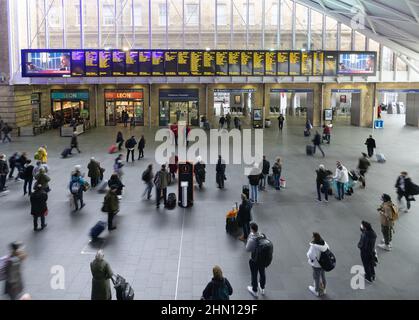 Bahnhof London Kings Cross, Bahnhofshalle; Passagiere, die das Abflugbrett betrachten, Bahnhof Kings Cross, London, Großbritannien Stockfoto