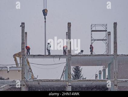 Demontage des alten Gebäudes. Der Rahmen des Gebäudes. Arbeiter, die das Gebäude demontieren Stockfoto