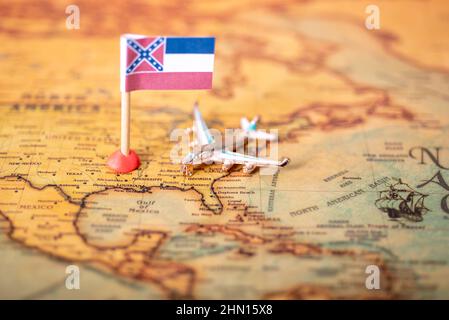 Die Flagge von Mississippi und das Flugzeug auf der Karte der alten Welt. Das Konzept des heimischen Tourismus und Erholung in Amerika. Stockfoto