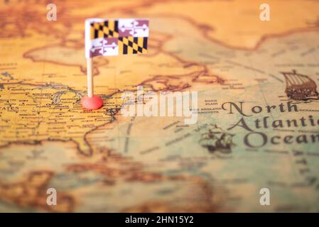 Die Flagge von Maryland auf der alten Weltkarte. Das Konzept des heimischen Tourismus und Erholung in Amerika. Stockfoto