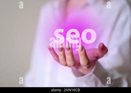 SEO in den gepflegten Händen einer Frau. Das Konzept der Förderung Website Traffic Ranking, die Optimierung Ihrer Website für Suchmaschinen-Ranking. Stockfoto