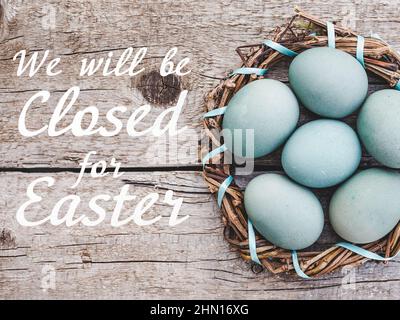 Schild mit der Inschrift Wir sind zu Ostern geschlossen. Ostereier mit bunten Farben bemalt. Nahaufnahme, drinnen, keine Leute. Herzlichen Glückwunsch Stockfoto