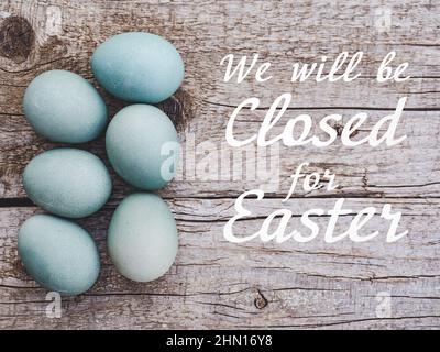 Schild mit der Inschrift Wir sind zu Ostern geschlossen. Ostereier mit bunten Farben bemalt. Nahaufnahme, drinnen, keine Leute. Herzlichen Glückwunsch Stockfoto