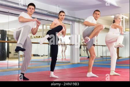 Eine Gruppe von Erwachsenen übt Beinkick im Selbstverteidigungstraining Stockfoto