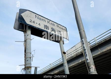 Straßenschild der Nam Kok Road in Hongkong von unten geschossen Stockfoto