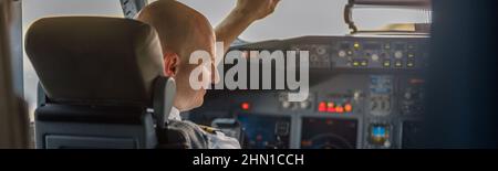 Fokussierter professioneller Pilot, der in einer Flugzeugkabine sitzt und zum Start bereit ist Stockfoto