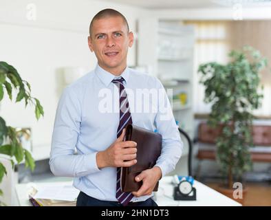 Selbstbewusster erwachsener Mann, der im Büro arbeitet Stockfoto