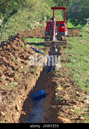 Verlegen von Rohren im Verbindungsgraben eines Hauses. Stockfoto