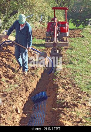 Verlegen von Rohren im Verbindungsgraben eines Hauses. Stockfoto