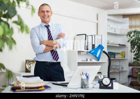 Selbstbewusster erwachsener Mann, der im Büro arbeitet Stockfoto