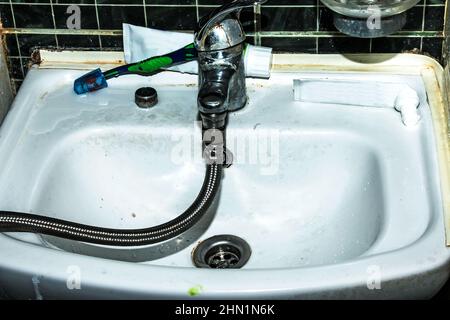 Überprüfung des Wasserzählers. An den Wasserhahn ist ein flexibler Wasserschlauch angeschlossen. Wassersparendes Konzept. Stockfoto