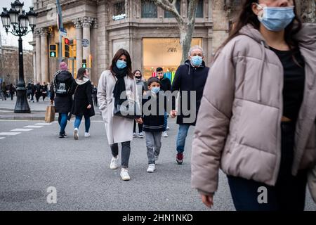 Spanien. 12th. Februar 2022. Eine Familie mit einem Kind wird am 12. Februar 2022 in der Innenstadt von Barcelona, Spanien, in der Straße Passeig de Gracia mit Gesichtsmaske spazieren gehen sehen. Gesichtsmasken sind in Spanien seit Februar 11 nicht mehr obligatorisch im Freien, werden aber immer noch in überfüllten Räumen empfohlen. (Foto von Davide Bonaldo/Sipa USA) Quelle: SIPA USA/Alamy Live News Stockfoto