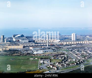 Ein Blick auf das Port Talbot Steelworks, ein integriertes Stahlproduktionswerk in Port Talbot, West Glamorgan, Wales, UK c. 1980. Die Hauptzufahrtsstraße zu dieser Zeit war die Cefn Gwrgan Road, die hier von rechts unten über eine Eisenbahnbrücke zum Werk führte. Diese Zufahrtsstraße wurde 2013 durch das Gebäude der Hafenstraße-Umgehungsstraße unterbrochen. Dieses Bild stammt aus einer Vintage-Farbtransparenz – einem Vintage-Foto aus dem Jahr 1970s/80s. Stockfoto