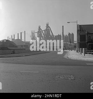 Ein Blick auf Central Road, Port Talbot, West Glamorgan, Wales, UK c.. 1960 von der Kreuzung mit der Commercial Road. Die Central Road war eine der Hauptzufahrtsstraßen zu den Stahlwerken (im Hintergrund zu sehen), die sich in den Nachkriegsjahren stark erweitert hatten (siehe Alamy-Bild 2HN1RG0 für einen Blick auf die Bauarbeiten an der Straßenbrücke über die Ffrwd Wyllt). Die Dyffryn-Kapelle befindet sich auf der rechten Seite. Schließlich war die Hauptroute zu den Werken über die Cefn Gwrgan Road. Beide Zufahrtsstraßen wurden jedoch durch das Gebäude der Hafenstraße im Jahr 2013 abgeschnitten – ein altes Foto aus dem Jahr 1950s/60s. Stockfoto