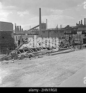 Ende 1950s wurden Bauarbeiten an einer neuen Brücke über die Ffrwd Wyllt an der Central Road, Port Talbot, West Glamorgan, Wales, Großbritannien, durchgeführt. Dies sollte eine der Hauptzufahrtsstraßen zu den Stahlwerken werden (im Hintergrund zu sehen), die sich in den Nachkriegsjahren stark erweitert hatten (siehe Alamy-Bild 2HN1RDT für einen Blick auf die fertige Brücke und Straße). Schließlich war die Hauptroute zu den Werken über die Cefn Gwrgan Road. Beide Zufahrtsstraßen wurden jedoch durch das Gebäude der Hafenstraße im Jahr 2013 abgeschnitten – ein altes Foto aus dem Jahr 1950s. Stockfoto