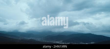 Wolkiger Himmel über Bergen Stockfoto