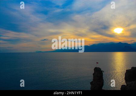 Sonnenuntergang, Sonne untergeht auf dem Meer und Berg wolkigen Tag Stockfoto