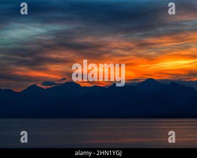 Sonnenuntergang, Sonne untergeht auf dem Meer und Berg wolkigen Tag Stockfoto