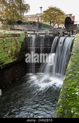 Schleuse auf dem Rochdale Kanal mit überlaufendem Wasser und undichten durch die Tore, Manchester, England, Großbritannien Stockfoto