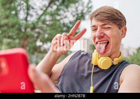 Basketballspieler in Ruhephase. Männlicher Athlet sitzt während eines Videoanrufs auf seinem Mobiltelefon. Stockfoto