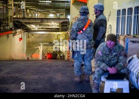 Gdynia, Polen. 13th. Februar 2022. Soldaten DER US-Armee werden auf dem Schiff ARC Defender im Baltic Container Terminal in Gdynia eingesetzt. Die US-Armee transportiert militärische Ausrüstung von Polen in die Vereinigten Staaten, nachdem sie für 9 Monate eingesetzt wurde, ist die langfristige Rotation der Ausrüstung. Eine weitere Einheit kommt, um gemeinsam mit den Truppen Großbritanniens, Kroatiens und Rumäniens im Rahmen gemeinsamer Militärmanöver in Polen und Europa zu trainieren. Kredit: SOPA Images Limited/Alamy Live Nachrichten Stockfoto