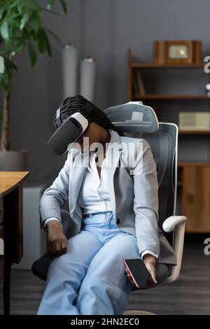 Müde schwarze Frau, die nach dem Spielen von VR schläft, weibliche Angestellte, die in einer Virtual-Reality-Brille schläft Stockfoto